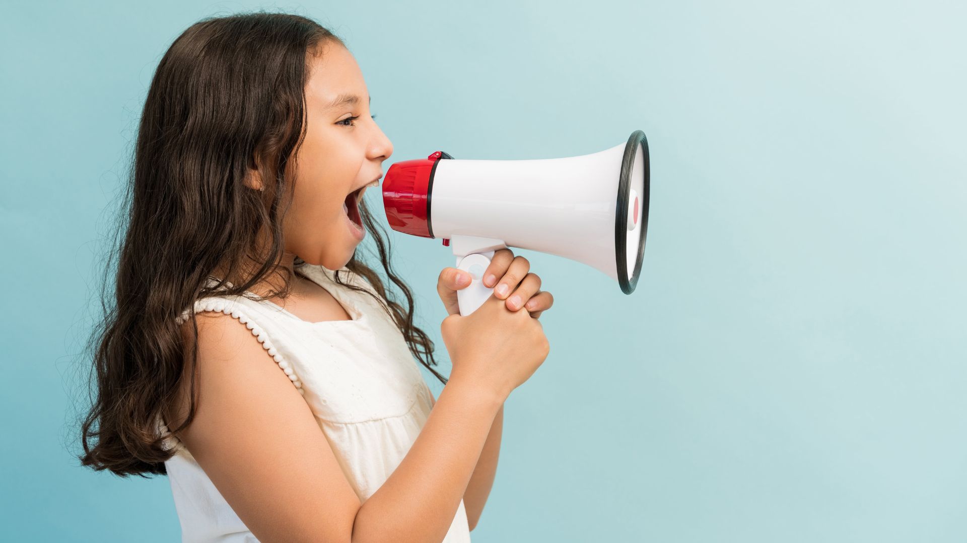vue laterale enfant sexe feminin criant dans megaphone se tenant debout fond uni min min min Canva2